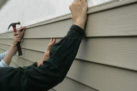 A person holding onto the side of a house