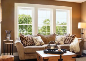 A living room with two large windows and a couch.