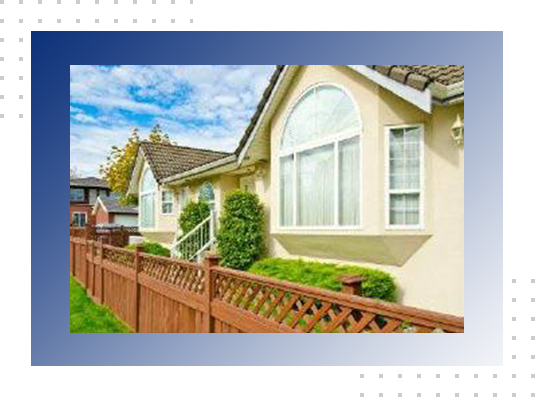 A house with a fence and bushes in front of it.