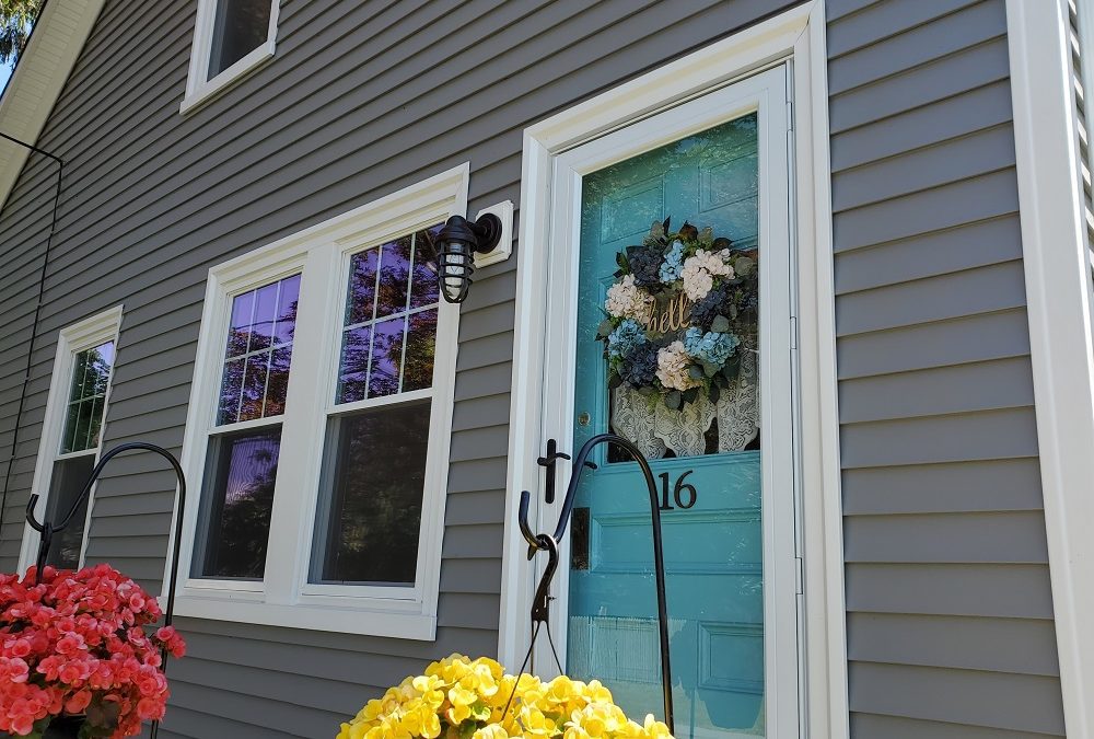 A blue door with flowers in front of it.