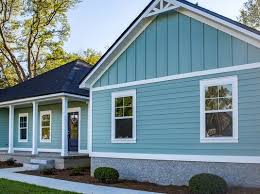 A blue house with white trim and black roof.