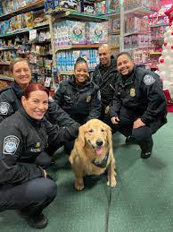 A group of people and a dog in uniform.