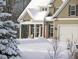 A house with snow on the ground and trees