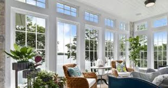 A living room with large windows and wicker furniture.