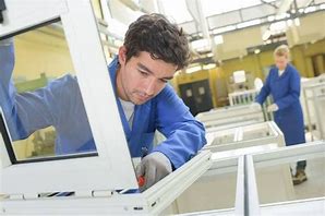 A man working on a window frame in a factory.