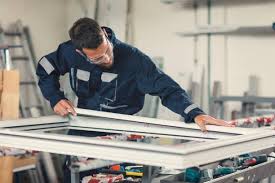 A man working on a window frame in a shop.