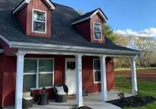 A red house with white trim and black shutters.