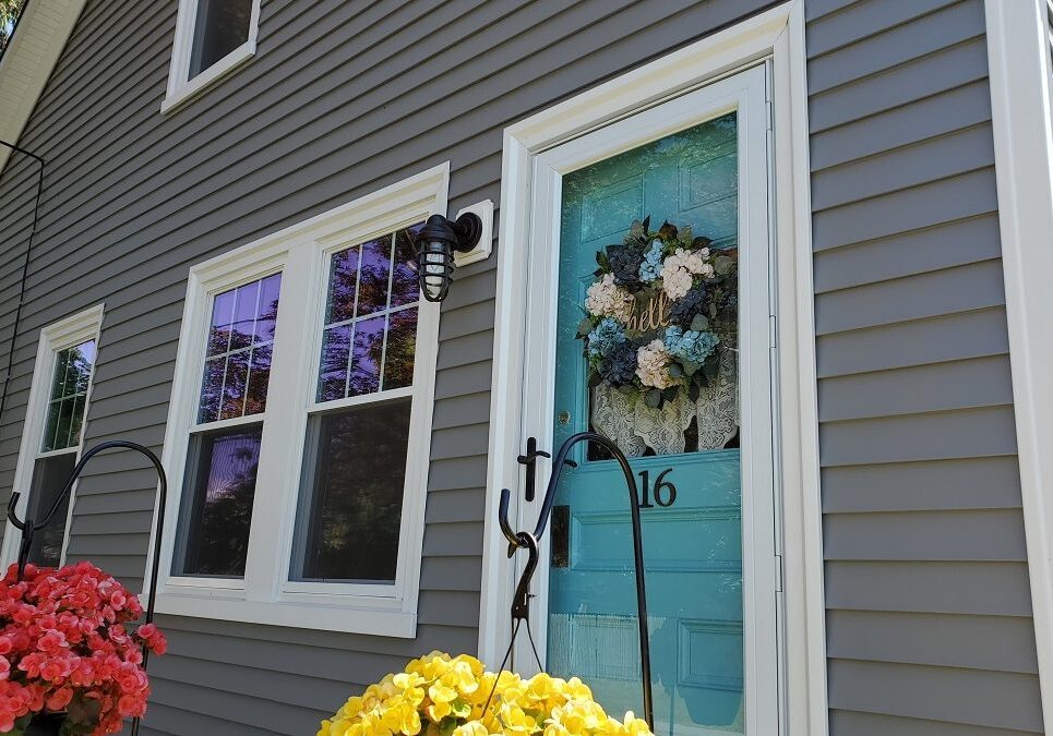 A blue door with flowers in front of it.